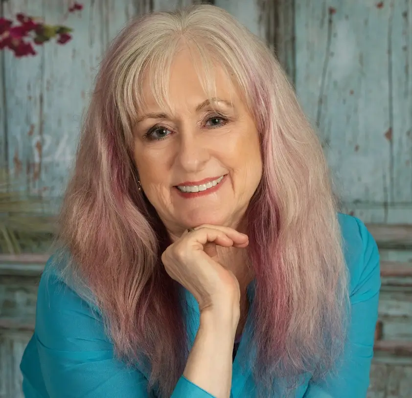 Smiling woman with long hair, blue shirt.