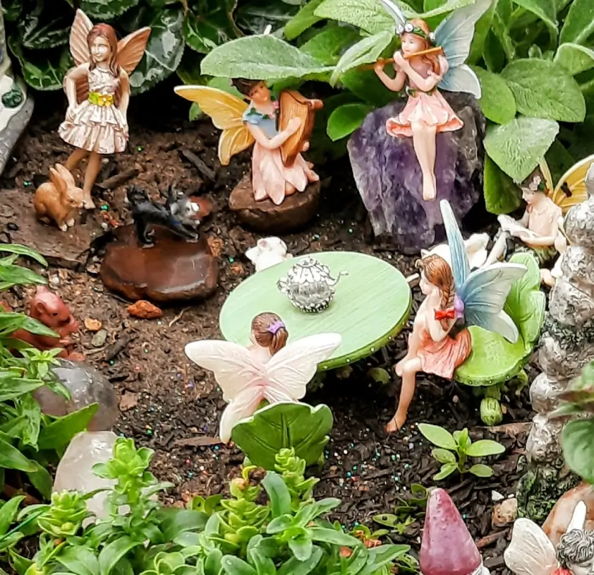 Fairy garden with miniature figures and plants.