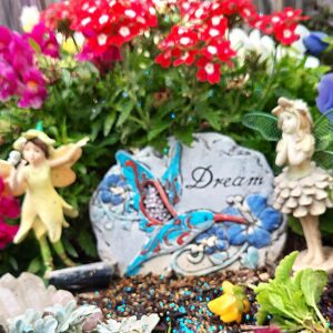 Decorative garden scene with fairies and a 'Dream' stone.