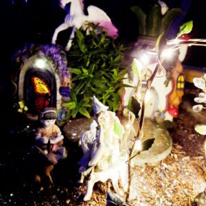 A mystical garden scene with glowing fairy lights and figurines.