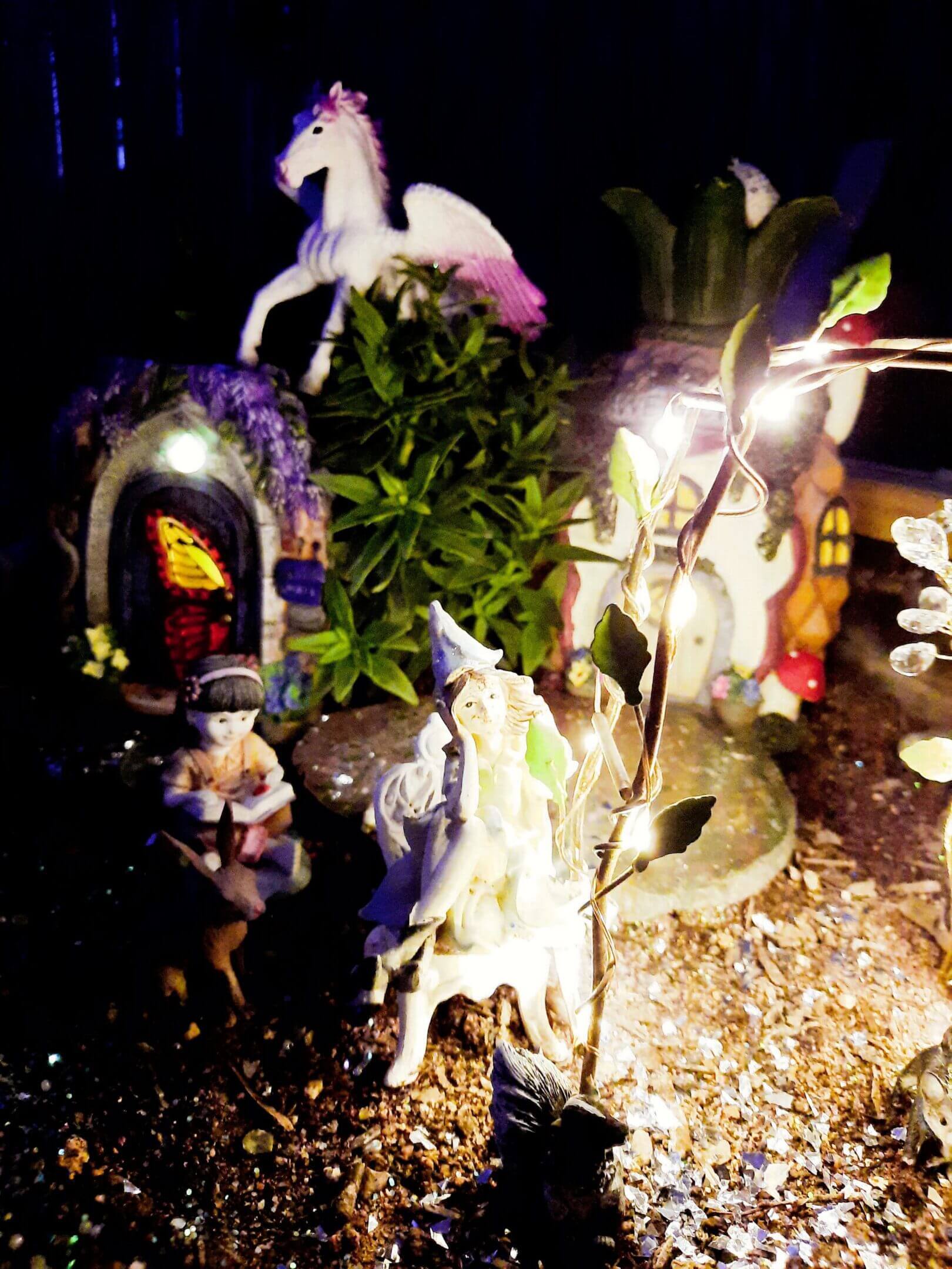 A whimsical fairy garden with tiny figurines and glowing lights.